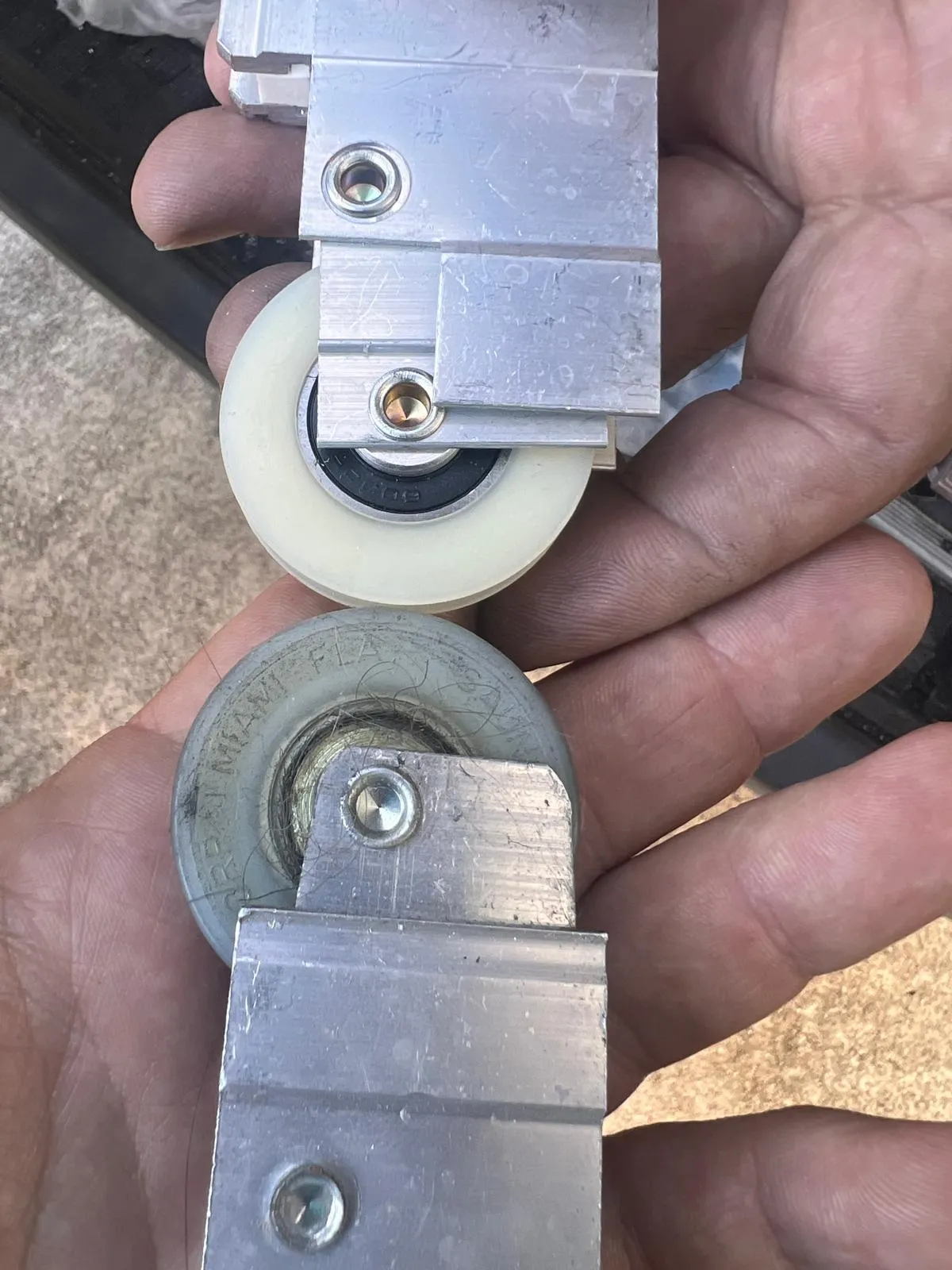 New and old sliding door wheels side by side showing wear comparison