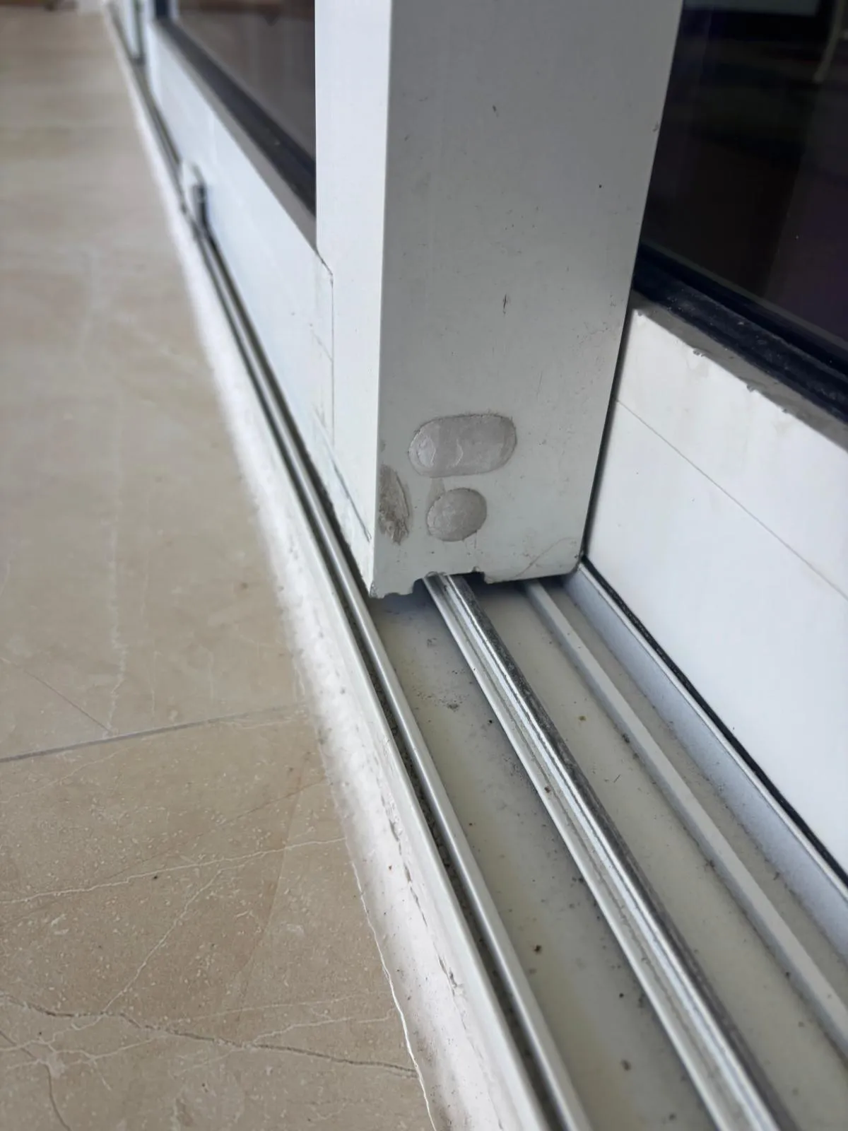 Sliding door bottom rail on track showing adjustment points