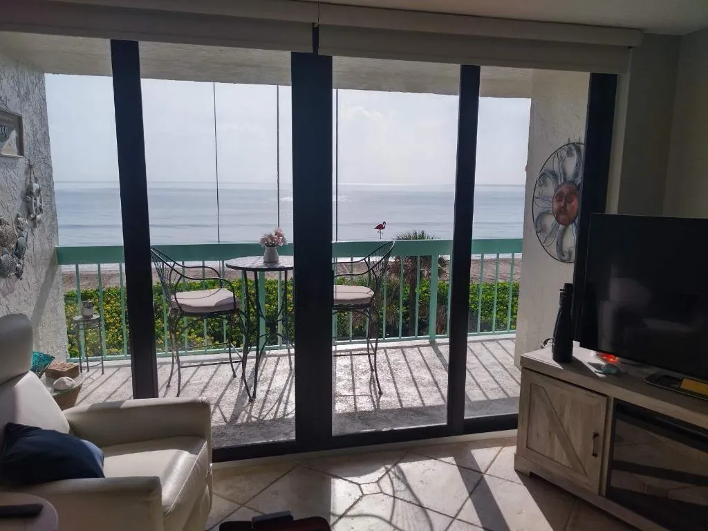 Oceanfront condo with large sliding glass doors overlooking the beach showcasing the coastal environment that affects sliding doors in Broward County