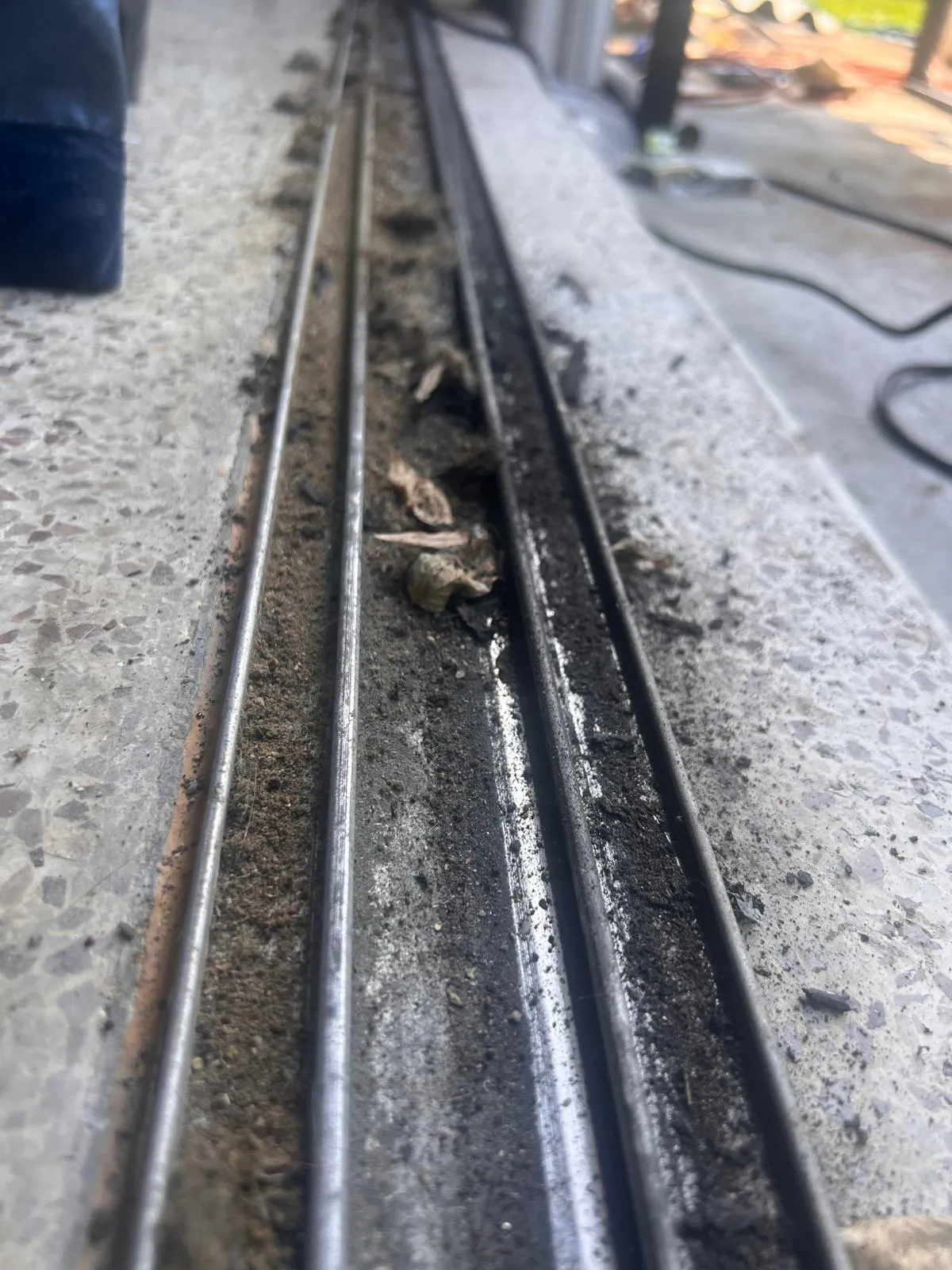 Before photo showing dirty corroded sliding door track needing repair in Pembroke Pines