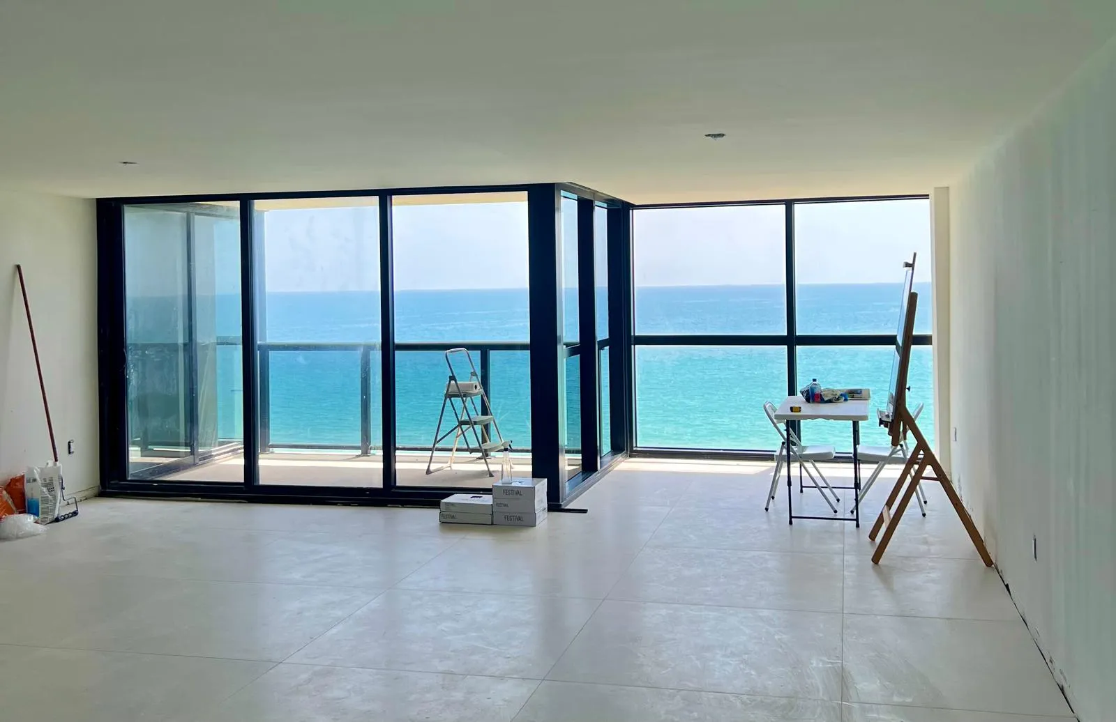 Professional technician servicing impact sliding doors in a Hallandale Beach oceanfront condo